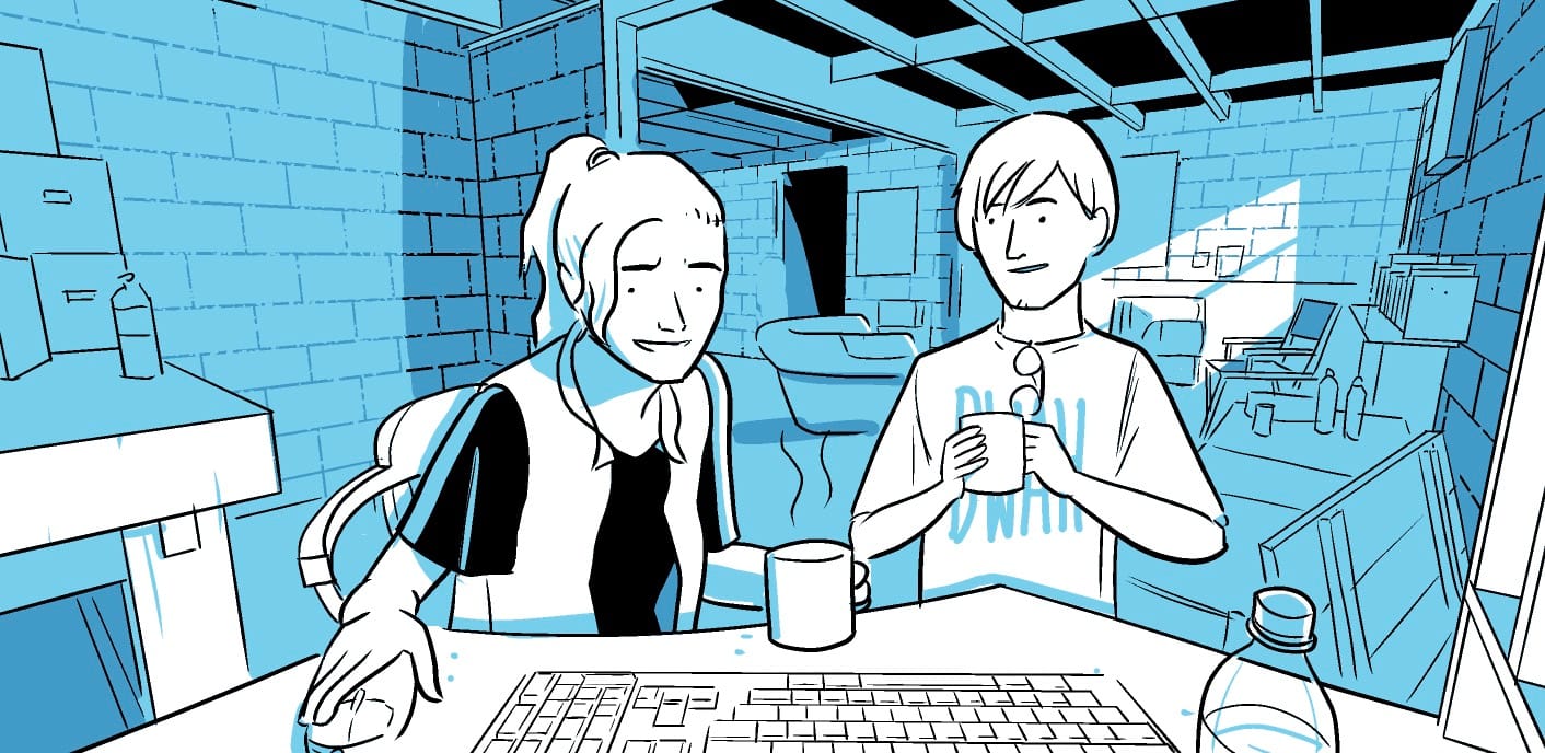 Two people sit in a cluttered basement, chatting over coffee at a computer.  They seem relaxed.